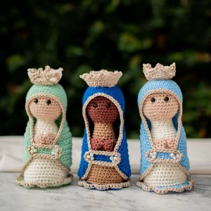 Três Nossa Senhora de amigurumi com mantos coloridos